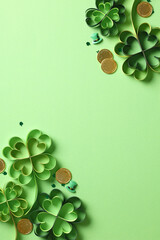 Wall Mural - St Patrick's Day vertical banner with four leaf clover paper art on green background. Flat lay, top view, copy space.