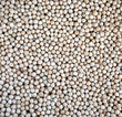 Crop of many dry round chickpea grains on flat surface as background top view closeup