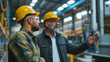 © KN Studio - Engineer consulting with the foreman in a modern industrial factory, discussing new production projects or investments. Team management in a manufacturing facility