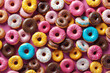 Top view of a variety of glazed donuts. Colorful donuts with icing as background. Various colorful glazed donuts with sprinkles.