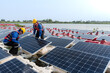 © ultramansk - Male workers repair Floating solar panels on water lake. Engineers construct on site Floating solar panels at sun light. clean energy for future living. Industrial Renewable energy of green power.