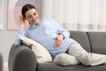 Canvas Print - Happy pregnant woman on sofa at home