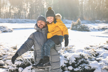 Sticker - Family portrait of happy father and his son in sunny snowy park