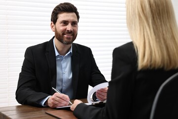 Sticker - Man signing document at table in lawyer's office