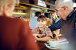 © Davor - Multigenerational family sitting in a cafe together