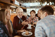 © Davor - Multigenerational family sitting in a cafe together