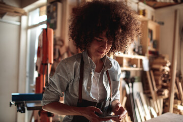 Wall Mural - Woman listening to music in a woodworking workshop