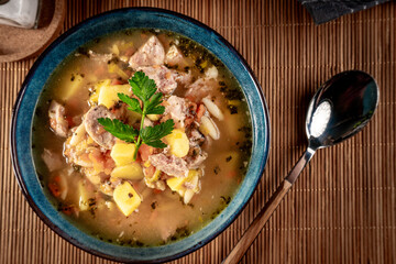 Canvas Print - Pea soup with pieces of white sausage, potatoes and small dumplings.