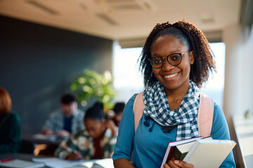 Wall Mural - Happy black female student at college classroom looking at camera.