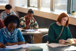 © Drazen - Black female student studying for upcoming exam at college classroom.