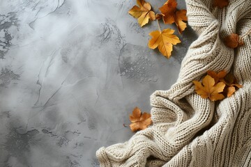 Poster - Beige knitted blanket on gray concrete background with copy space representing autumn and winter