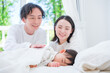 © taka - 昼寝する赤ちゃんを見守る夫婦