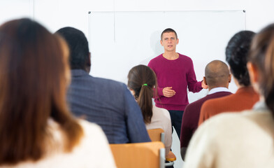 Wall Mural - Coach businessman giving talk at modern office conference to multiethnic team