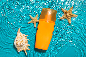 Sunscreen cream with starfishes and seashells in water on color background