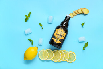 Wall Mural - Composition with bottle of fresh ginger beer, mint, lemon slices and ice cubes on blue background