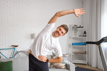 Canvas Print - Sporty young man doing exercise at home