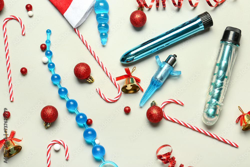 Sex toys with Christmas decor on light background