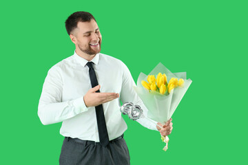 Wall Mural - Handsome man with bouquet of flowers and balloon in shape of figure 8 on green background. International Women's Day celebration