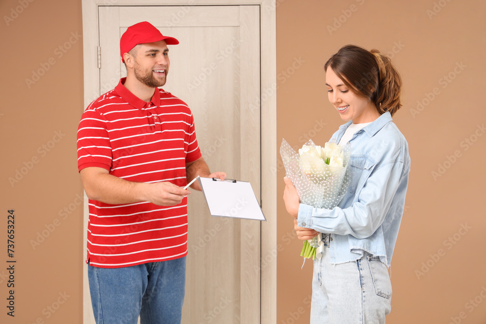 Young woman receiving flowers from courier