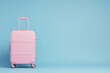 A magenta rectangle rolling suitcase on electric blue background