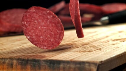 Poster - Pieces of salami fall onto a wooden board. Filmed on a high-speed camera at 1000 fps. High quality FullHD footage