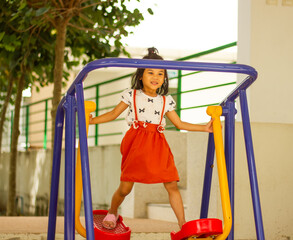 happy little girl climbing in sports equipment outdoor