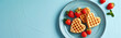 Plate with heart-shaped Belgian waffles and strawberries on a blue background. Generative AI