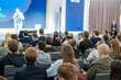 © Anton Gvozdikov - Audience attentively listening to a speaker at a business event, representing learning and corporate engagement.
