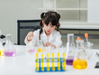 © Bangkok Click Studio - Asian little cute girl students in lab coat making test tube science experiments chemical laboratory in study room at school. Education research and development concept learning kids.