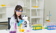 Asian young woman female laboratory professional scientist concentrated in a white lab coat, protective eyeglasses making test tubes looking microscope research medicine experiments in chemical lab.