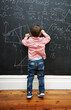 © Katie/peopleimages.com - Math, blackboard and child writing in school for learning, development and young boy genius in classroom. Kid, numbers and formula on chalkboard with knowledge for education, growth and solution
