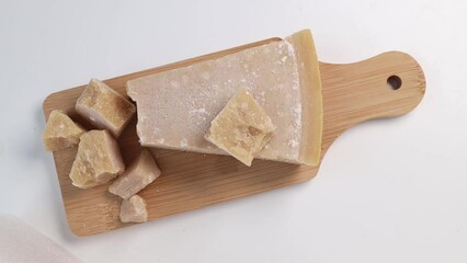 Wall Mural - Place a board with Parmesan cheese on the table. a piece of grana padano cheese