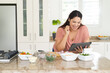 © Wavebreak Media - Young biracial woman enjoys cooking at home using a tablet, with copy space