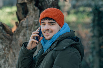 Wall Mural - young man bundled up in winter talking on mobile phone