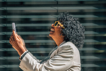 Wall Mural - business woman with mobile phone smiling out loud