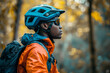 © Georgii - Close-up of male mountain biker in safety helmet and sunglasses riding a bike. Handsome determined African American athlete in picturesque autumn forest. Active lifestyle concept.
