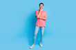 Full body photo of handsome confident guy wear stylish shirt jeans trousers holding hand on chin isolated on blue color background