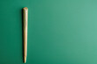 a cannabis rolled joint on a green background, overhead flat lay studio shot