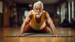 an old man with a beard does push-ups on the floor in the gym. concept of a healthy lifestyle in old age, life expectancy, veganism, Pilates. defocus, blur