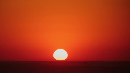 Wall Mural - A timelapse of the sunrise captures the changing colors of the sky, from bright orange to soft yellow, time lapse.