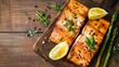 Grilled salmon with lemon, asparagus on the wooden background
