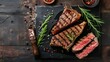 Steaks T-bone. Sliced beef grilled T-bone or porterhouse meat steak with spices rosemary and pepper on black marble board on old wooden background.