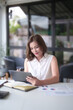 © snowing12 - Asian businesswomen reading marketing business report to checking financial chart data on digital tablet and writing notes while analyze investment and market stock of new startup in outside office