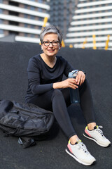 Sticker - A fit and athletic Caucasian woman prepares for a run in the urban stadium, exuding vitality.