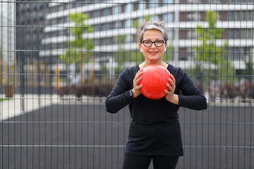 Wall Mural - A Caucasian woman embraces a healthy lifestyle, exercising with a ball indoors for fitness and strength.