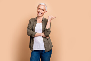 Poster - Photo of successful business development specialist woman with short gray hair point finger company isolated on beige color background