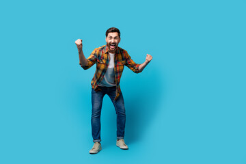 Sticker - Full size photo of handsome young male fists scream support sport team dressed stylish checkered outfit isolated on blue color background