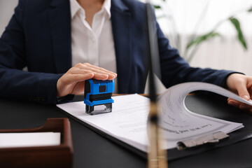 Poster - Notary stamping document at table in office, closeup