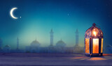 Fototapeta Las - Ramadan lantern shines at night. Islamic greeting Eid Mubarak cards for Muslim Holidays..Arabic. Crescent moon and stars.