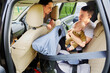 Parents place infant in rear facing child car seat before traveling.